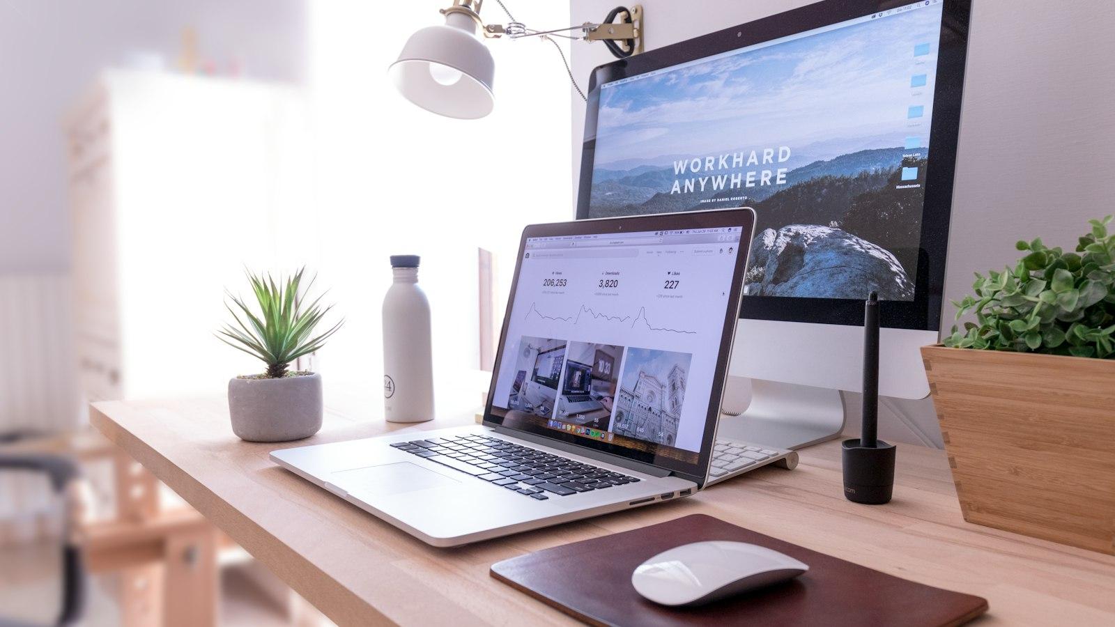 A bright desk with a laptop and monitor