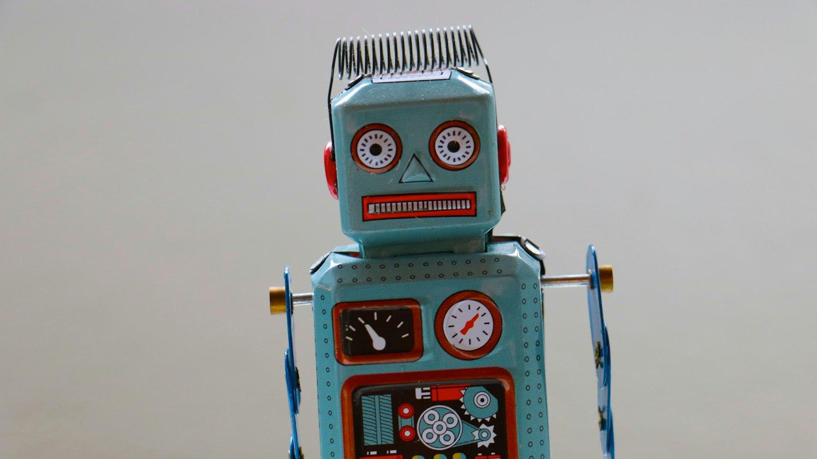 A retro tin toy robot standing against a plain background